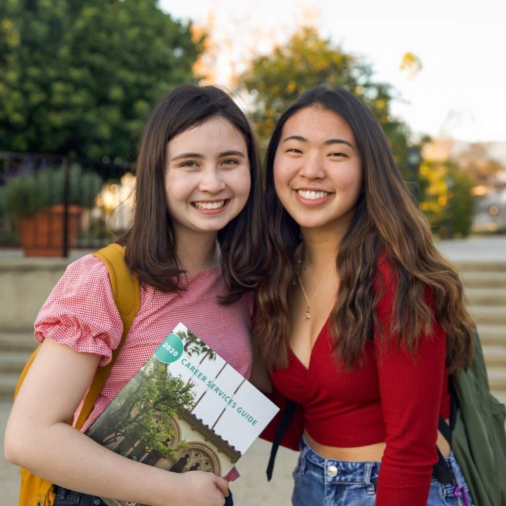 Two students smiling on campus at swag, Claremont California
